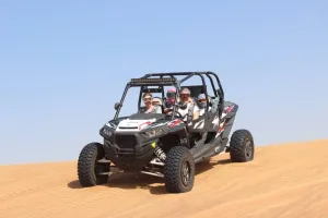 A group of adventure seekers enjoying a thrilling dune buggy ride Dubai in a Polaris RZR Turbo Buggy over the golden desert dunes.