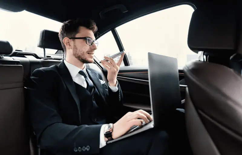 Hire a Chauffeur for business or leisure – A professional driver in a suit standing beside a luxury car, ready to assist a passenger in Dubai & Abu Dhabi.
