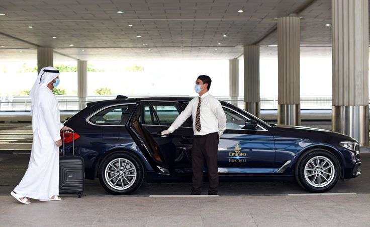 Professional chauffeur welcoming a business traveler with luxury car service in Dubai