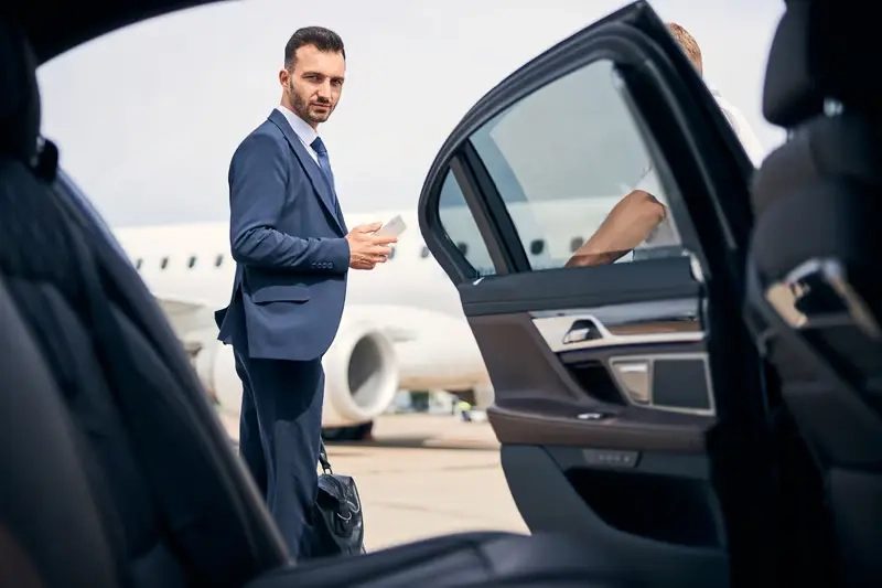Luxury airport transfer service in the UAE with a private chauffeur assisting with luggage, monitoring flight schedules, and providing a smooth, stress-free travel experience.