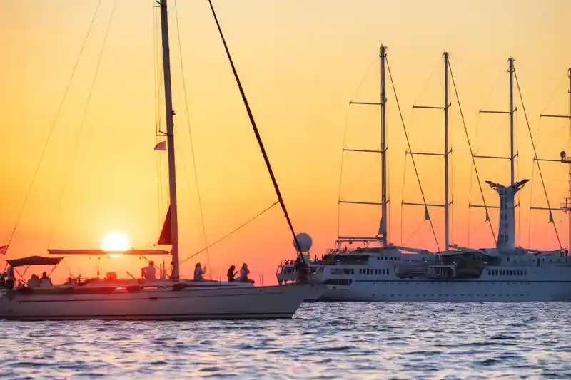Luxury sunset yacht cruise in Dubai sailing through the Arabian Gulf with stunning views of the city skyline and a serene sunset atmosphere.